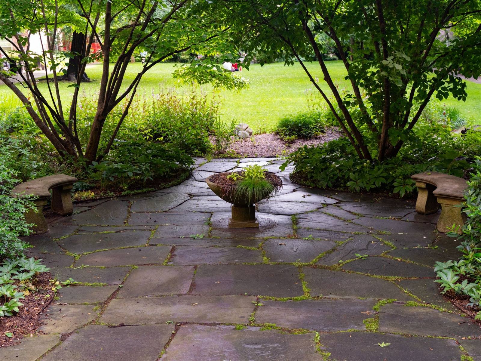 Finished flagstone patio surrounded by garden greenery