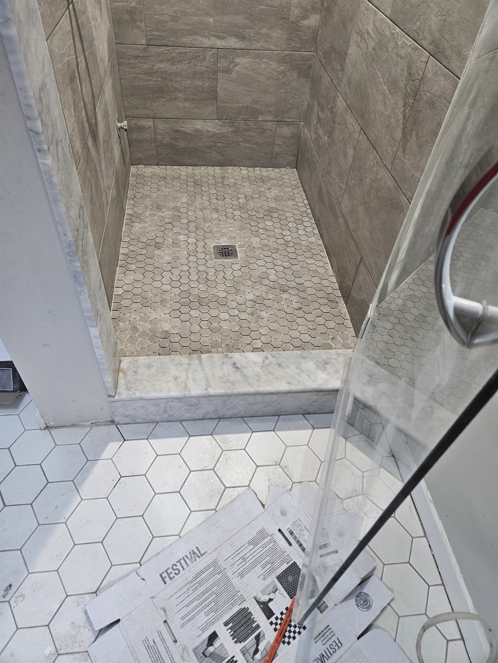 Gray hexagon shower tile meeting a carefully finished corner