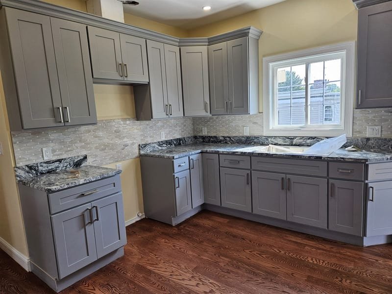 Gray kitchen with marble hexagon backsplash and granite counters