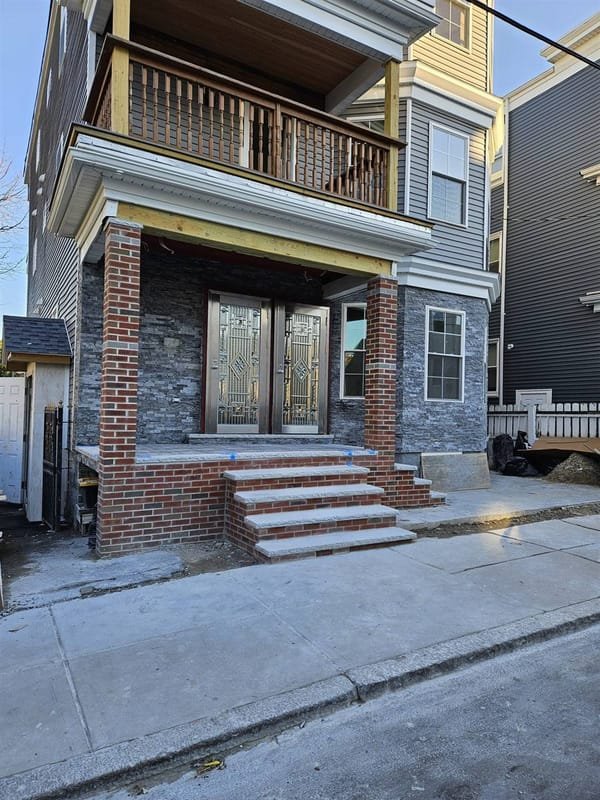 Brick columns, stone veneer and granite steps on a rebuilt front entry