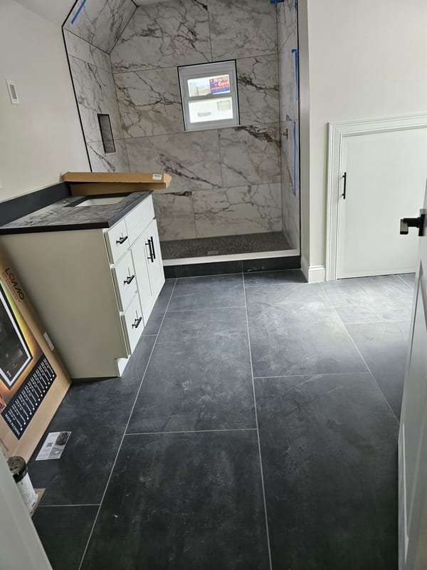Marble shower with a dark slate-look tile floor