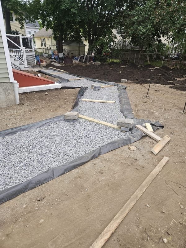 Compacted gravel base prepared for a paver walkway