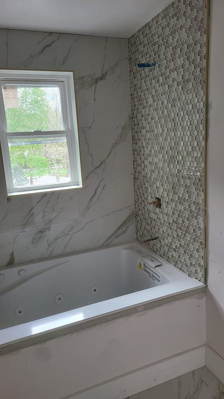 Marble tub surround with a tan hexagon accent wall