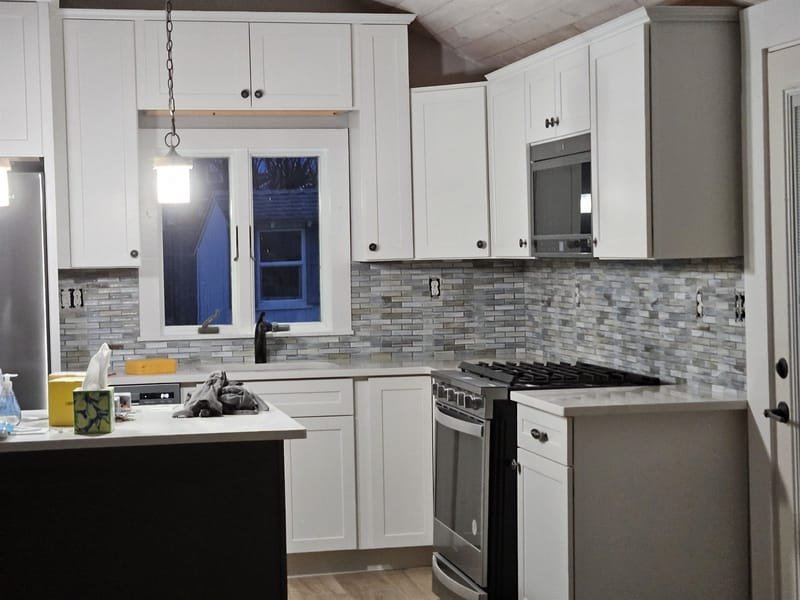 White kitchen with a gray glass mosaic backsplash