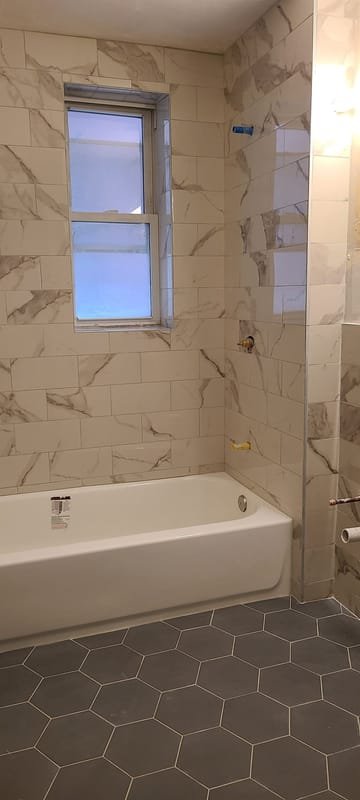 Marble tub surround with a gray hexagon floor